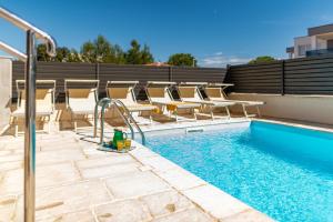einen Pool mit Chaiselongues und einem Pool-Pool in der Unterkunft Villa Kristina ZadarVillas in Zaton + 30 Fotos