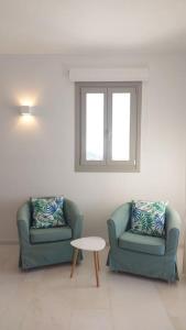 two chairs and a table in a living room at Aelia Preciosa in Kampos Paros