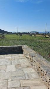 a stone walkway with a field in the background at Aelia Preciosa in Kampos Paros