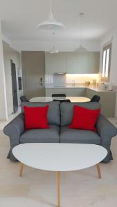 a living room with a blue couch with red pillows at Aelia Preciosa in Kampos Paros +10 photos