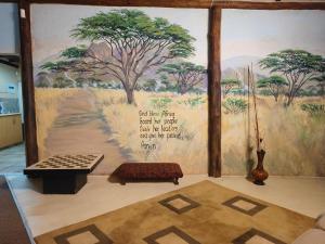 ein Zimmer mit einer Wand mit einem Wandbild eines Baumes in der Unterkunft Shangrila-innibos Country Lodge in Hartbeespoort
