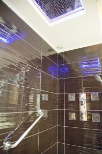 a bathroom with a shower with a black tiled wall at Perfect Modern High Floor apt with all Paris View in Paris