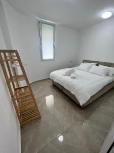 a bedroom with a bed and a wooden staircase at סוויטת קריית צאנז in Netanya