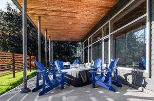 金斯頓的住宿－Comfort Suites Kingston Central，露台设有蓝色椅子和门廊上的桌子