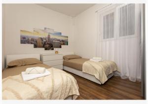 een slaapkamer met 2 bedden en een schilderij aan de muur bij Apartman Filip in Jesenice