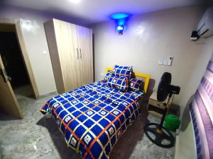 Mofide Queens Apartments (MQA) في Onigbongbo: غرفة نوم بها سرير مع ضوء أزرق