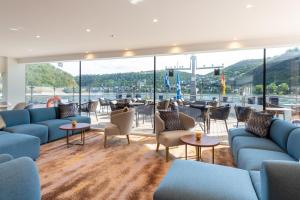 a lobby with blue couches and tables and a large window at Thurgau Gold - Art Basel Riverboat Hotel I in Basel