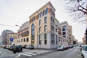 a large building on a city street with parked cars at Lusso Urbano: Luminoso e centrale appartamento in Milan