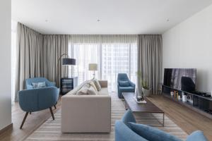 uma sala de estar com um sofá e cadeiras e uma televisão em 2BR apartment in Jumeirah Living Marina Gate em Dubai