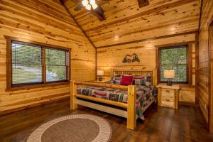 een slaapkamer met een bed in een blokhut bij The Lodge at Smoky Escape in Sevierville