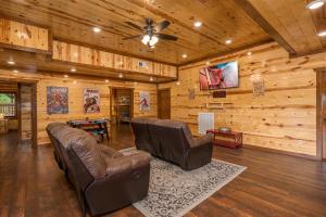 een woonkamer met 2 stoelen en een plafondventilator bij The Lodge at Smoky Escape in Sevierville