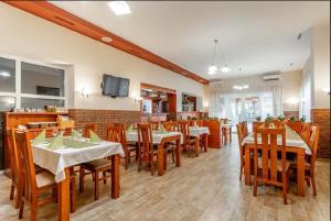 um restaurante com mesas e cadeiras de madeira e uma televisão em Penzion U Císařské cesty em Držovice