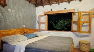 1 dormitorio con cama y ventana en Podocarpus cottages, en Naro Moru