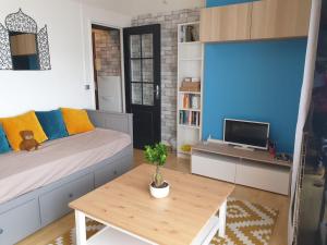 um quarto com uma cama, uma mesa e uma televisão em Les Maisons Acajou - Ivry-sur-Seine em Ivry-sur-Seine