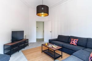 バルセロナにあるAB Calabria Apartmentのリビングルーム(青いソファ、薄型テレビ付)