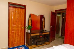 una camera da letto con porta in legno e comò con specchio di Enk apartments a Nairobi