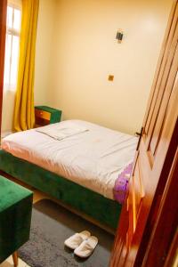 una camera con un letto e un paio di scarpe di Enk apartments a Nairobi