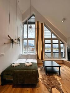 a bedroom with a bed and a table and windows at Soca Valley Suites in Bovec