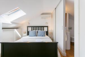 1 dormitorio con 1 cama grande con almohadas azules en Loft Bairro Alto, en Lisboa