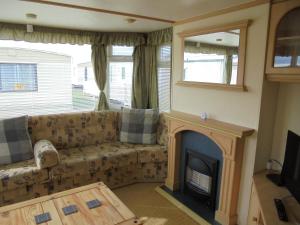 a living room with a couch and a fireplace at Seaview Belvedere 6 Berth Blow heated FREE WIFI in Ingoldmells