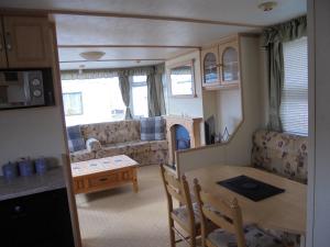 a kitchen and living room with a table and a caravan at Seaview Belvedere 6 Berth Blow heated FREE WIFI in Ingoldmells