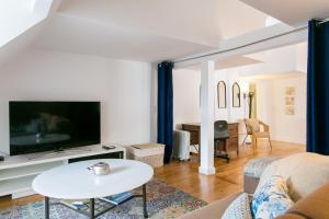 uma sala de estar com um sofá e uma televisão em Loft Bairro Alto em Lisboa