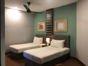 a room with two beds and a ceiling fan at Perhentian Island Resort in Perhentian Islands