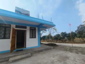 a small blue and white building with a door at EVELENA Guest House in Cherrapunji