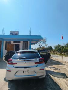 a white car parked in front of a gas station at EVELENA Guest House in Cherrapunji