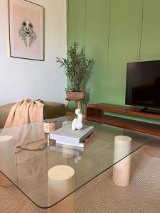 een woonkamer met een glazen tafel en een televisie bij Immeuble serigne cheikh Saliou Mbacke in Dakar