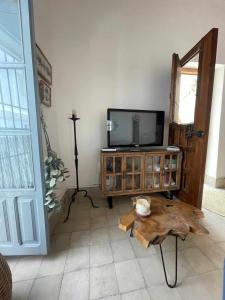 - un salon avec une télévision et une table en bois dans l'établissement AntiQua centro de Vejer con wifi Grupo AC Gestion, à Vejer de la Frontera
