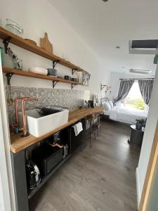 una cocina con fregadero y una cama en una habitación en Little Clover en Malborough