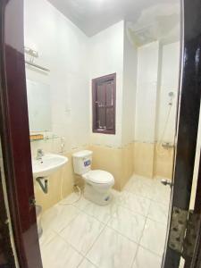 y baño con aseo y lavamanos. en Khách Sạn Hải Miên, en Ho Chi Minh