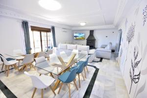 ein Zimmer mit Tischen, Stühlen und einem Sofa in der Unterkunft Villa rural en Málaga con piscina y vistas al mar in Málaga