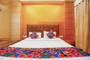 博帕尔FabHotel The Oasis - Maharana Praatap Nagar的卧室里有一张大床，床铺上还有色彩缤纷的枕头
