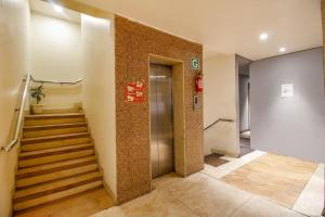 a hallway with stairs and a elevator in a building at FabHotel The Oasis in Bhopal