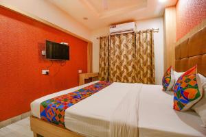 a bedroom with a bed and a tv on a wall at FabHotel The Oasis in Bhopal