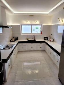 a large white kitchen with a sink and a window at Jay's Villa 2 (Friendship) in Angeles