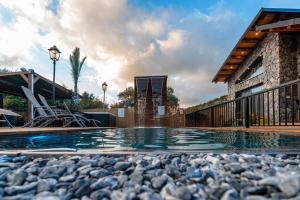 a swimming pool in front of a house at אחוזת המלכים - וילה מטריפה ומבודדת עם בריכה פרטית מחוממת ומקורה עם ג'קוזי in Yarka