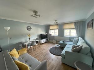 a living room with blue couches and a dining room at Apartment with King Bed & Free Parking in London in Southall