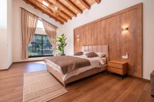 a bedroom with a large bed and a wooden wall at אחוזת המלכים - וילה מטריפה ומבודדת עם בריכה פרטית מחוממת ומקורה עם ג'קוזי in Yarka