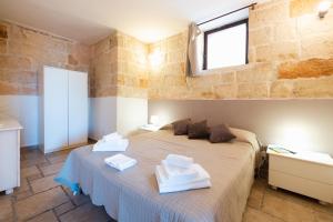 a bedroom with a bed with towels on it at CASA LAPILLI in Polignano a Mare