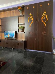 a living room with wooden cabinets and a television at Om Sai Nilayam Guest house in Tirupati