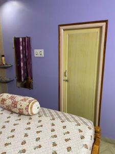 a bedroom with a bed and a green door at Om Sai Nilayam Guest house in Tirupati