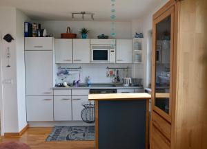 a kitchen with white cabinets and a counter top at Inselliebe in Groß Zicker