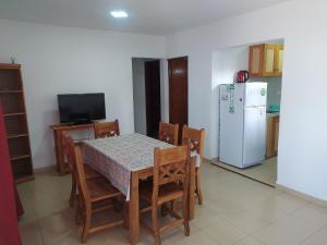 a kitchen with a table and chairs and a refrigerator at Complejo LUMA in Villa Dolores