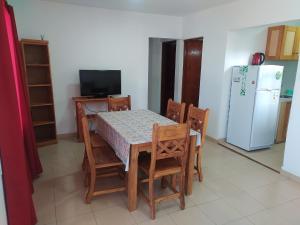 cocina con mesa, sillas y nevera en Complejo LUMA en Villa Dolores