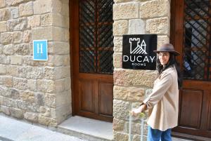 a woman standing in front of a building with a sign at Ducay Rooms in Olite