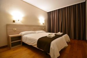 una habitación de hotel con una cama grande con toallas. en Ducay Rooms, en Olite
