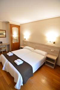 a bedroom with a large bed with two towels on it at Ducay Rooms in Olite